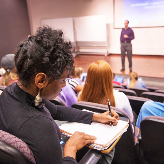 Girl takes notes in lecture